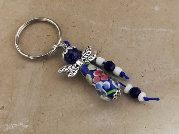 Sleutelhanger beschermelfje lang donkerblauw met bloemen