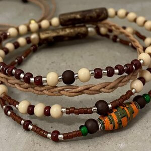Armbandset creme bruin met tussenkralen oranjegroen en brons lang vlechtleer
